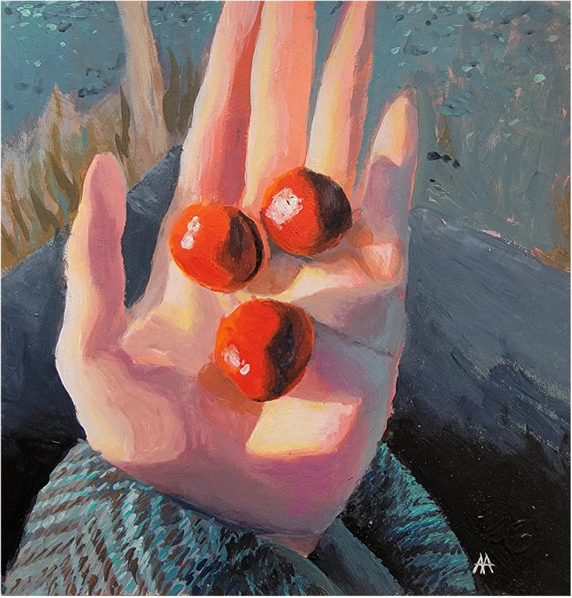 An open hand holding three cherries