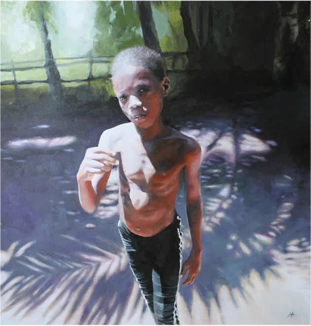 A boy standing in dappled shade under palm leaves