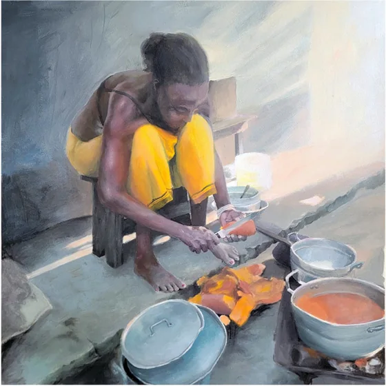 A woman in yellow crouches over cooking pots in sunlight